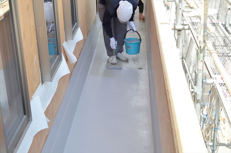 ベランダ床の防水工事を行う職人jpg